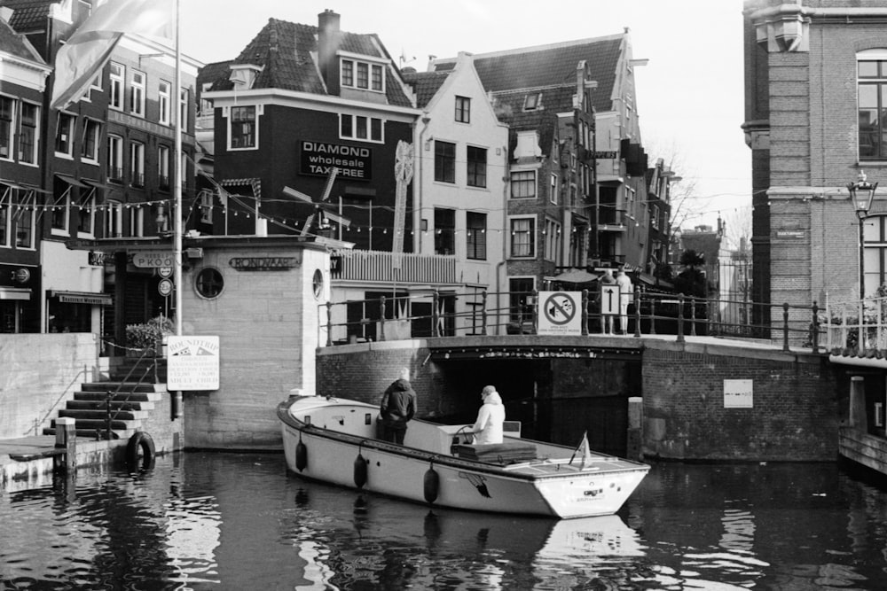 grayscale photo of 2 person sitting on boat