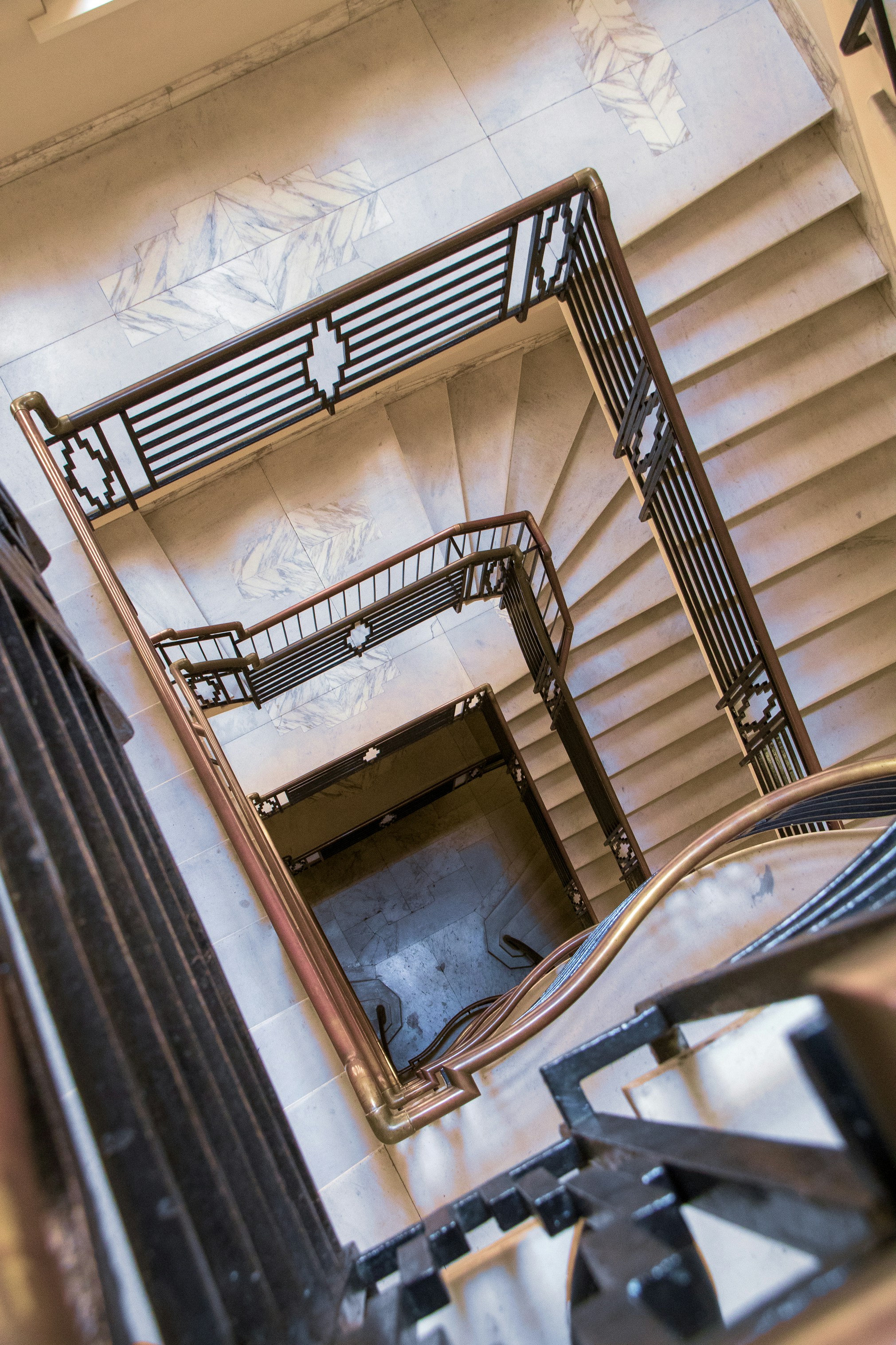 A spiral staircase taken from the top floor, looking down.