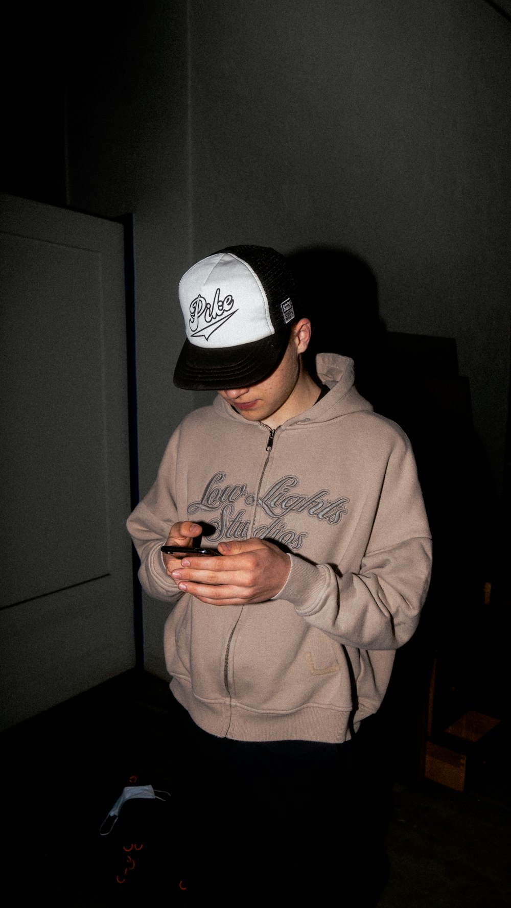 man in gray hoodie wearing black and white fitted cap