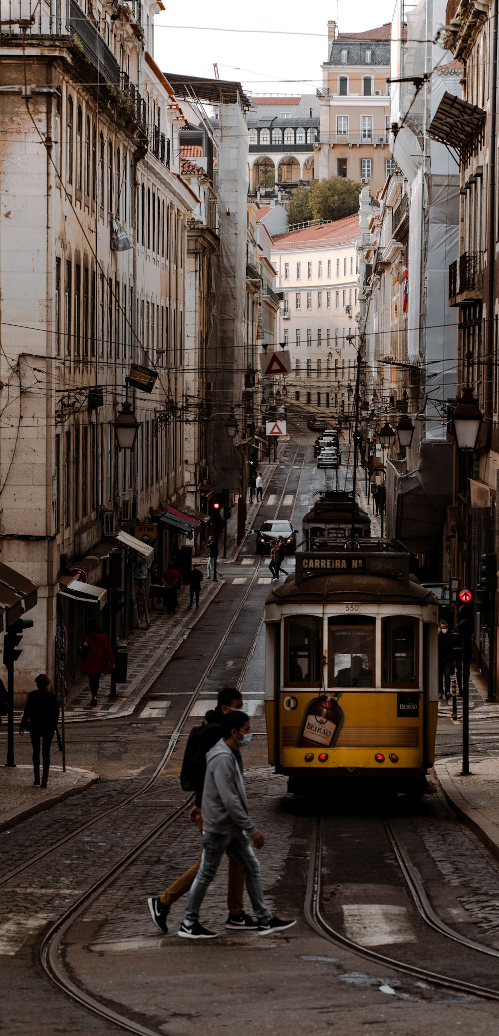 Tram giallo sulla strada vicino agli edifici durante il giorno