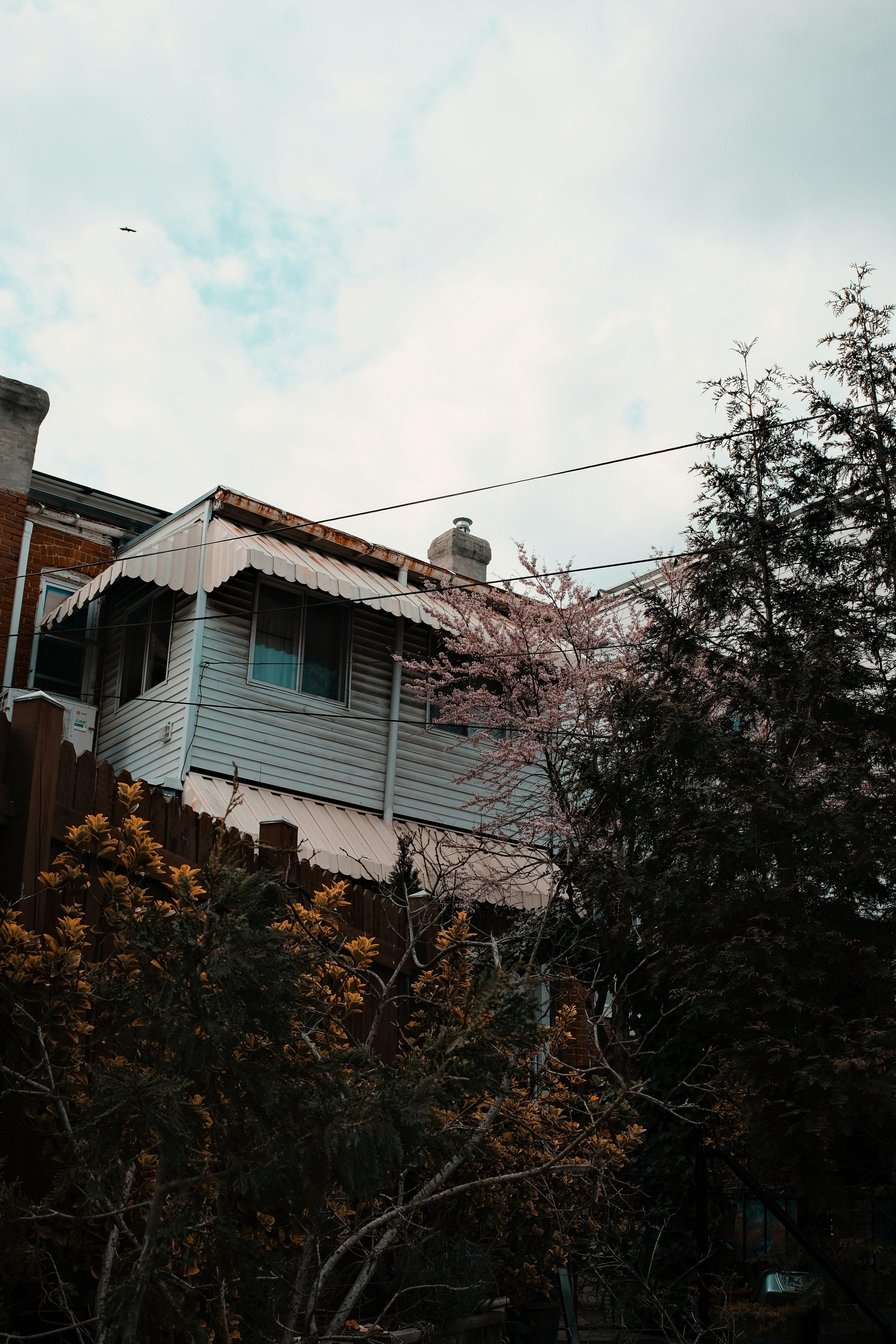 Casa de madera blanca y marrón bajo nubes blancas durante el día
