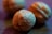 Close-up view of walnuts with detailed textures and a shallow depth of field, creating a smooth, blurred background. The lighting casts a warm and slightly bluish hue over the image.