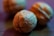 Close-up view of walnuts with detailed textures and a shallow depth of field, creating a smooth, blurred background. The lighting casts a warm and slightly bluish hue over the image.
