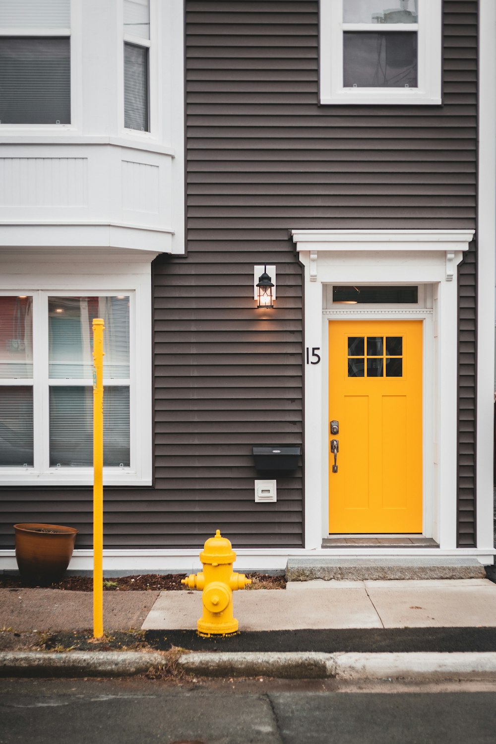 yellow and black street lamp beside white wooden door