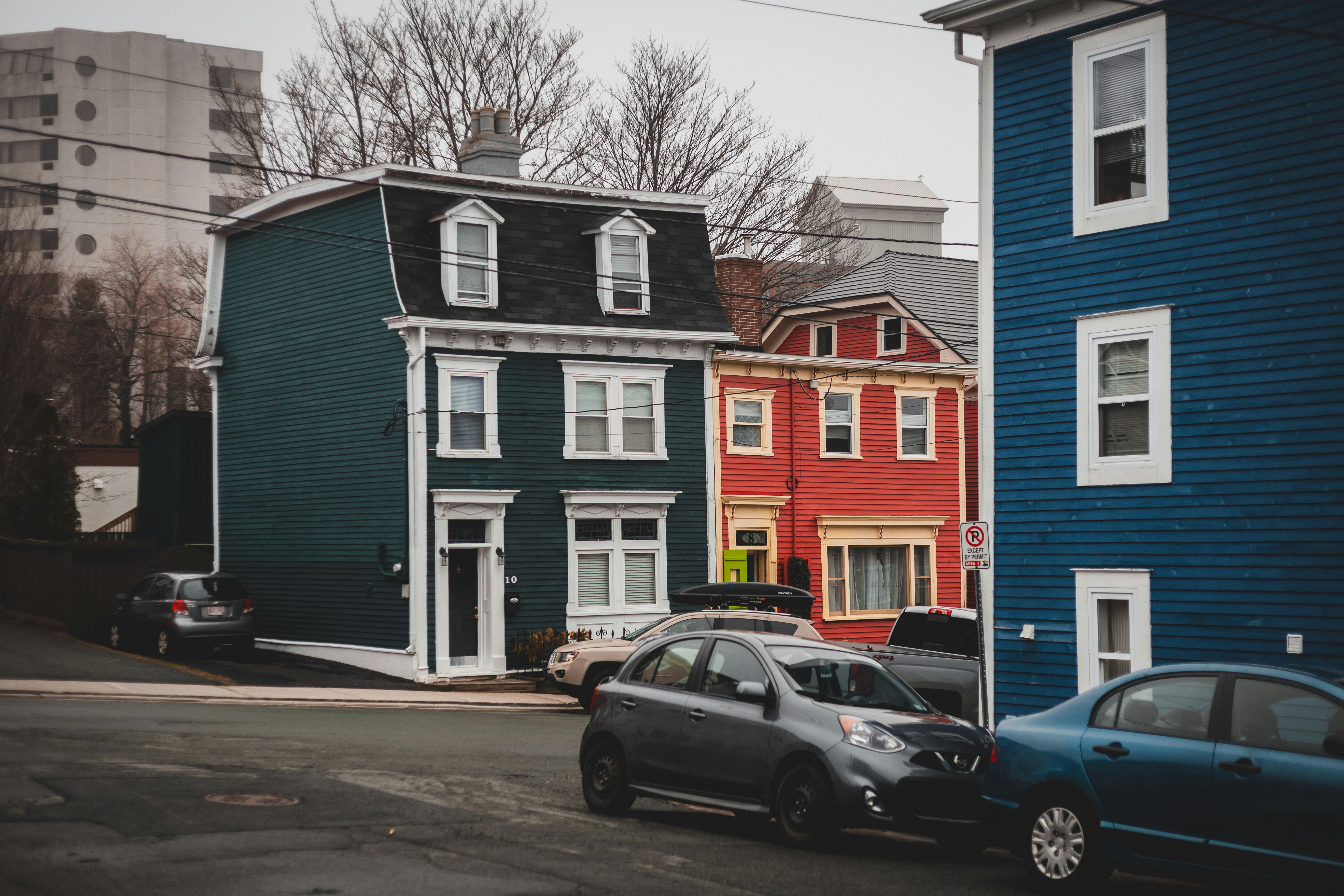 black sedan parked beside blue and orange concrete building during daytime, 