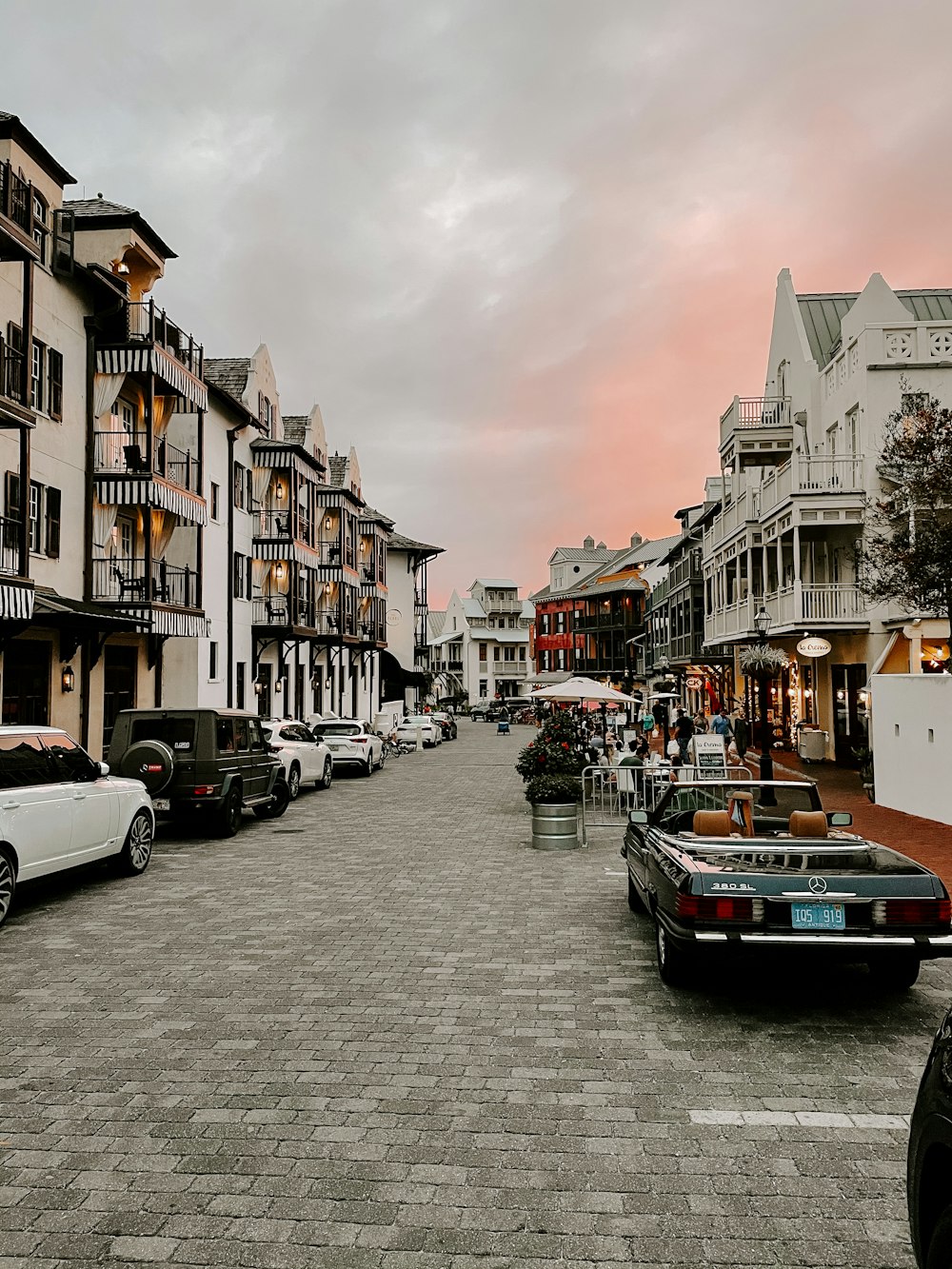 cars parked beside the road in between buildings during daytime