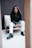 woman in black long sleeve shirt and white pants sitting on white couch