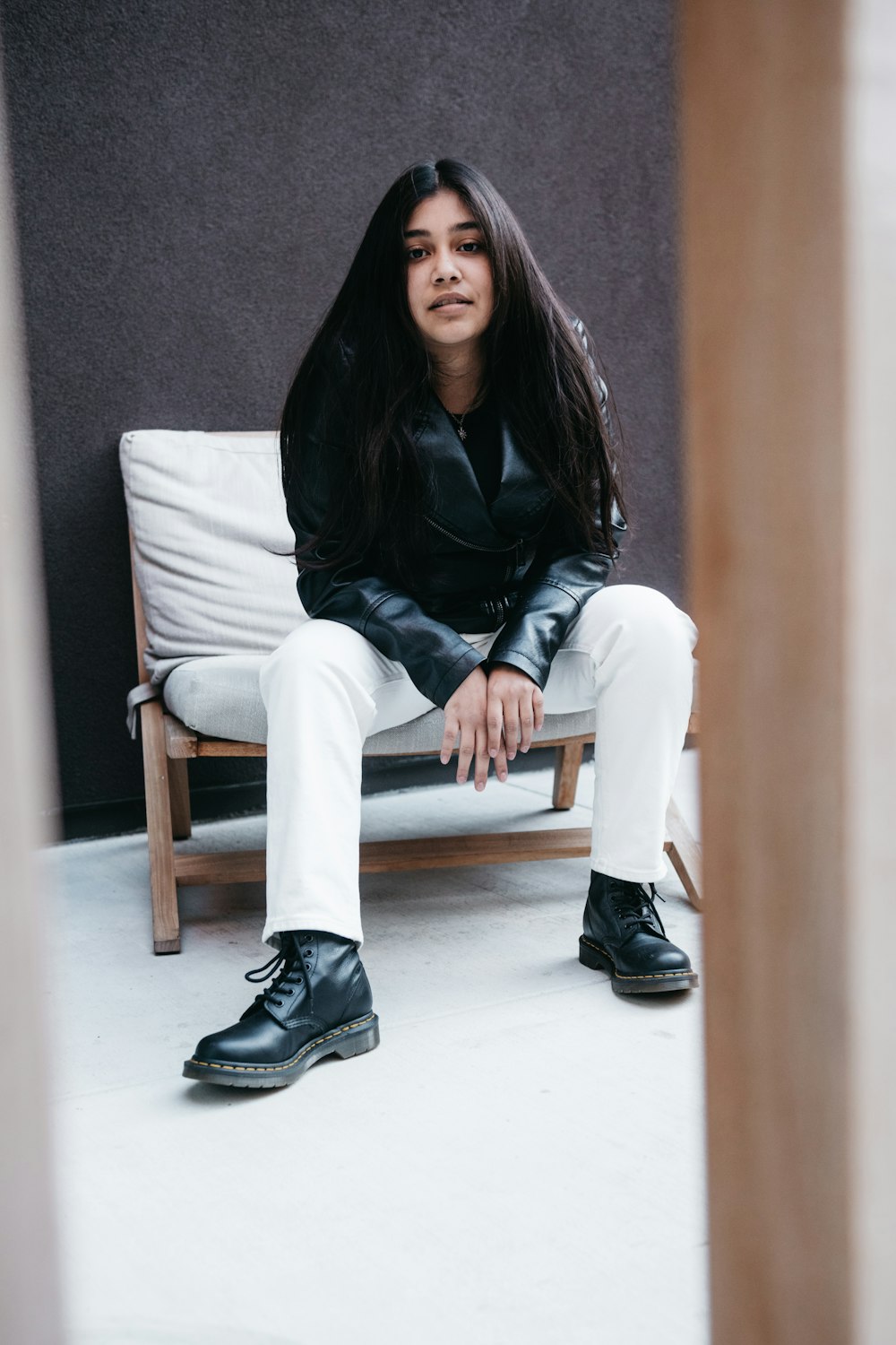 woman in black long sleeve shirt and white pants sitting on white couch