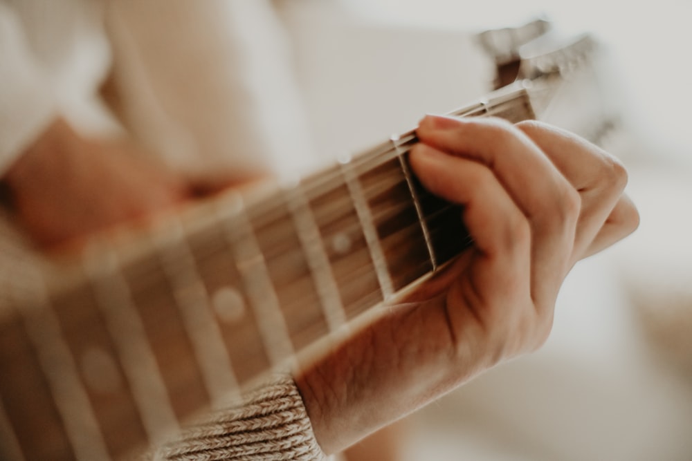 person playing guitar during daytime