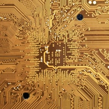 Close-up of brushed gold circuits intertwined with modern architectural lines.