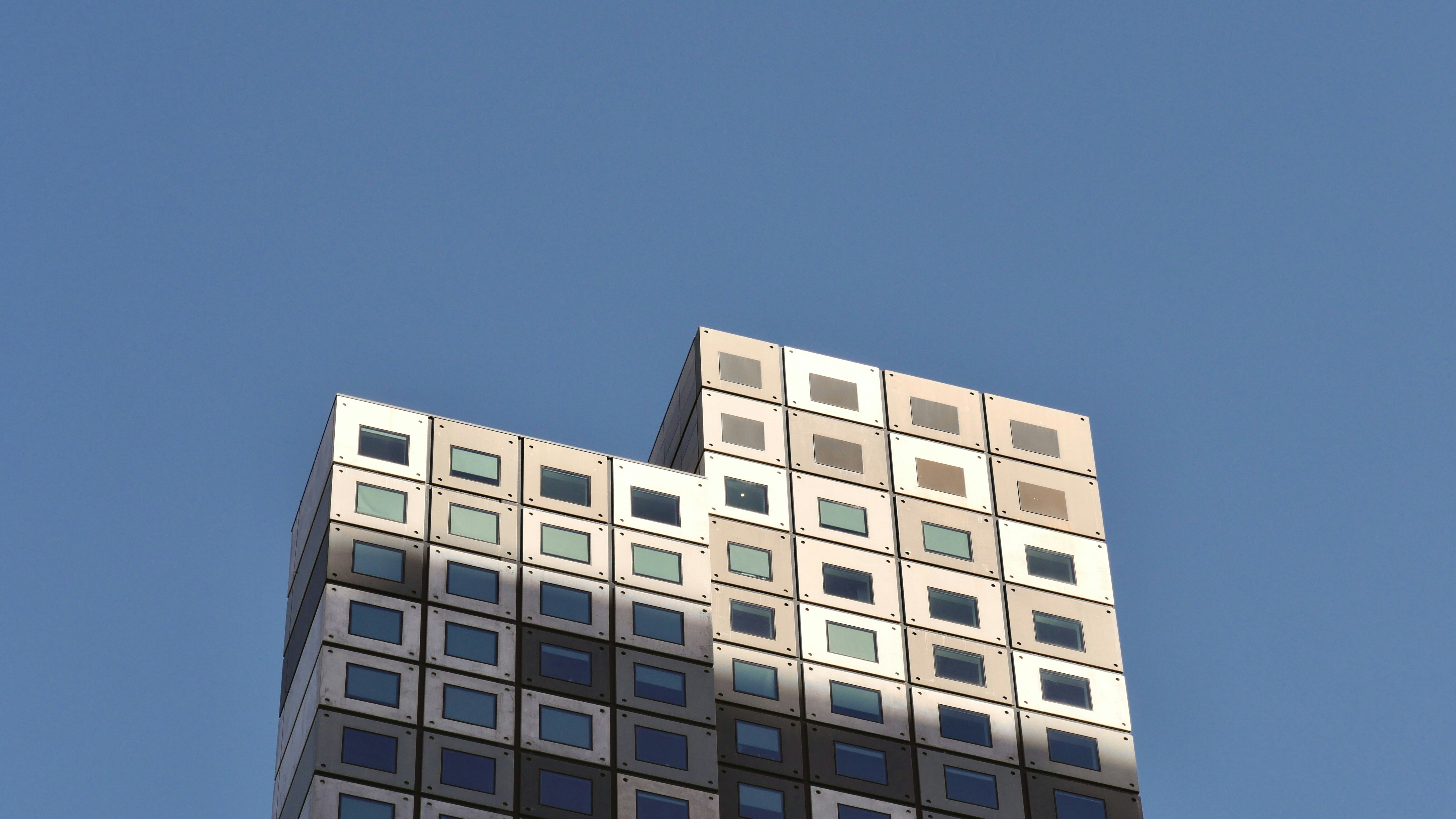Edifício de concreto branco sob o céu azul durante o dia