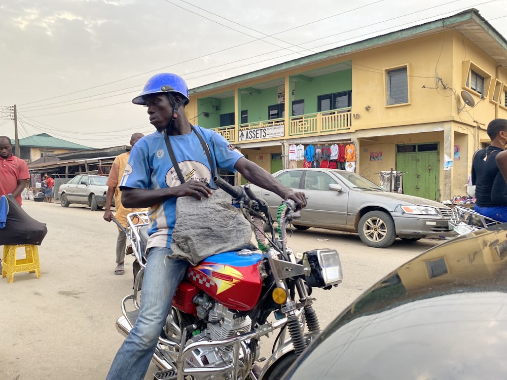 man in blue shirt riding motorcycle during daytime