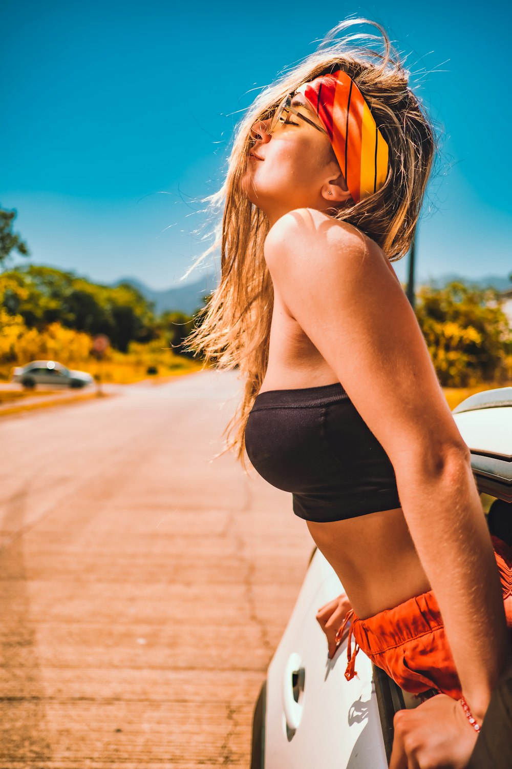 woman in black sports bra and black shorts standing on sidewalk during daytime