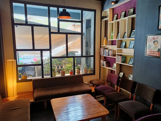 A cozy, well-lit common area in Bhairava Boys PG with students relaxing and chatting.