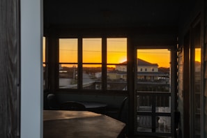 Room with a large window showcasing Islamabad’s scenic hills at sunset.