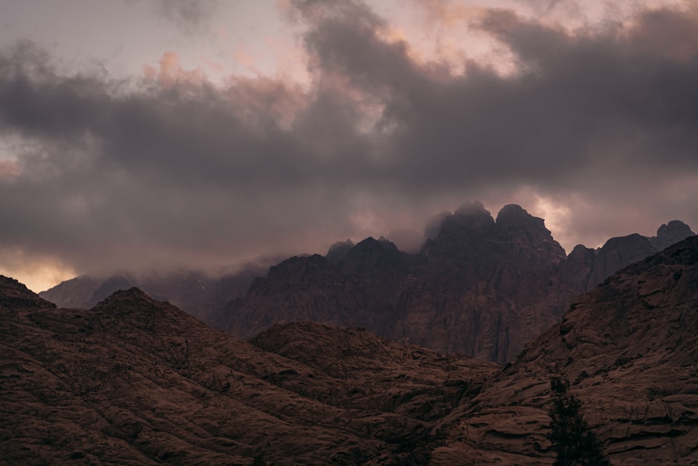 montanha rochosa marrom sob céu nublado durante o dia