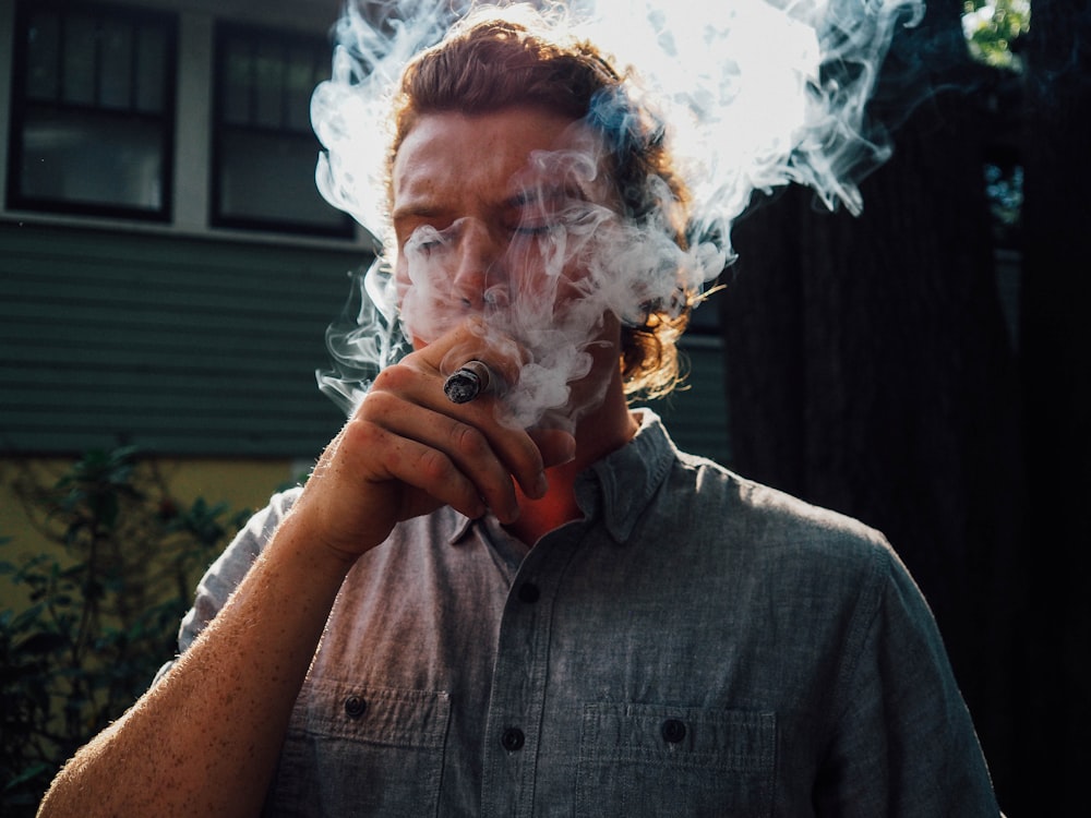 man in gray button up shirt smoking