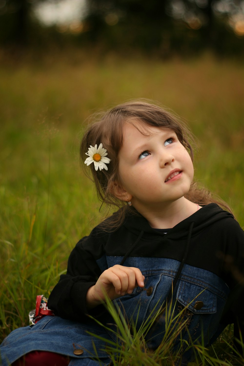 girl in black jacket with white flower on ear