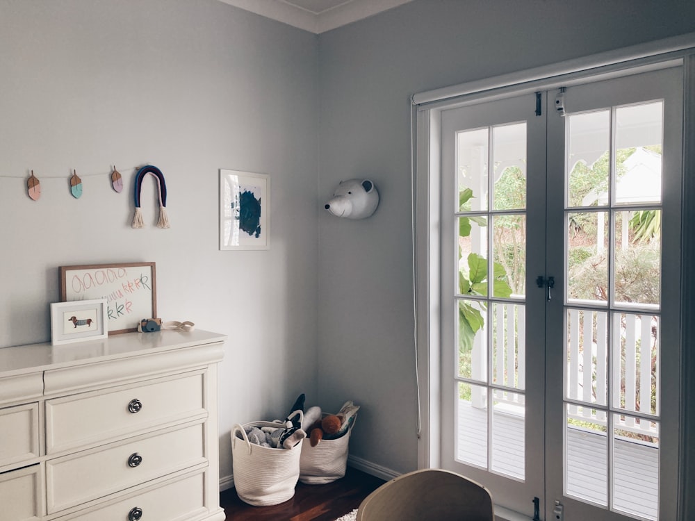 white wooden drawer beside white wooden framed glass window