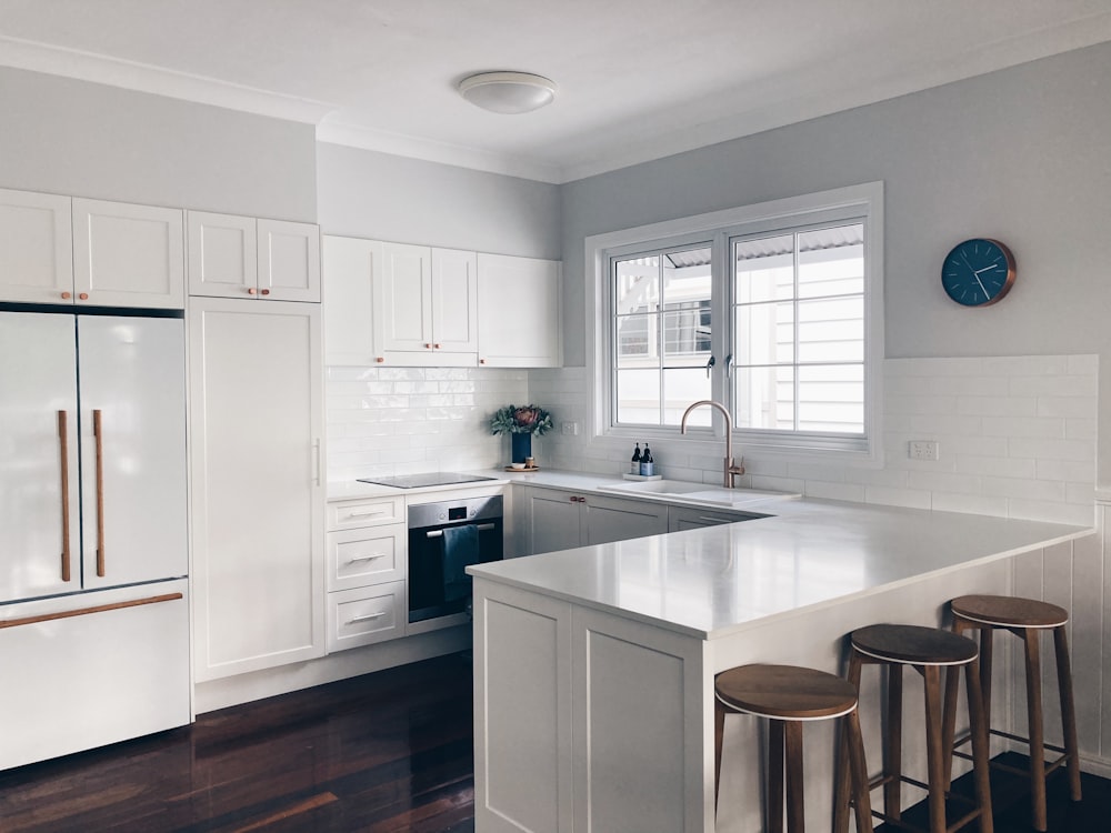 Mueble de cocina de madera blanca cerca de puerta de madera blanca