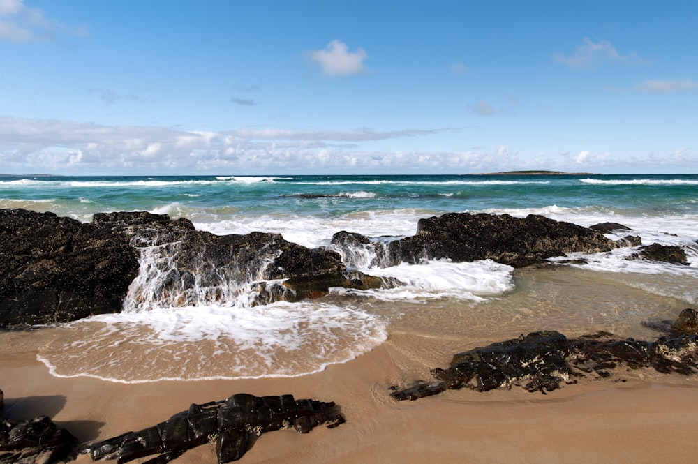 ocean waves crashing on shore during daytime