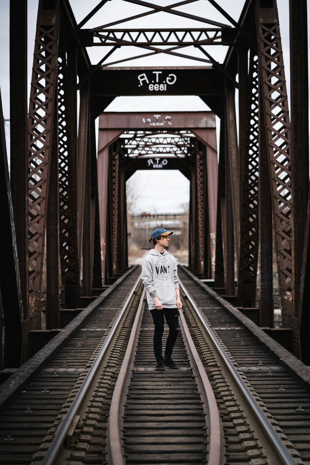 白いジャケットを着た女性が電車のレールの上を歩く