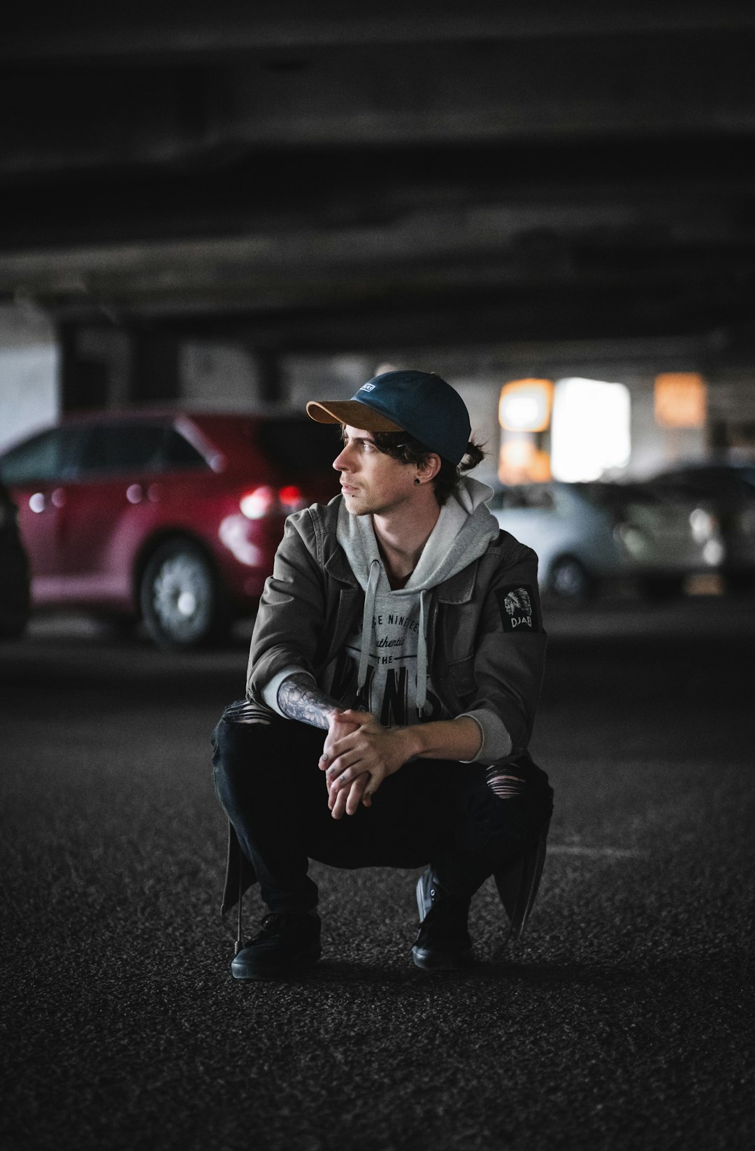 man in black jacket and black pants sitting on road during daytime