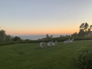 A serene oceanfront hotel terrace at sunset with plush lounge chairs.