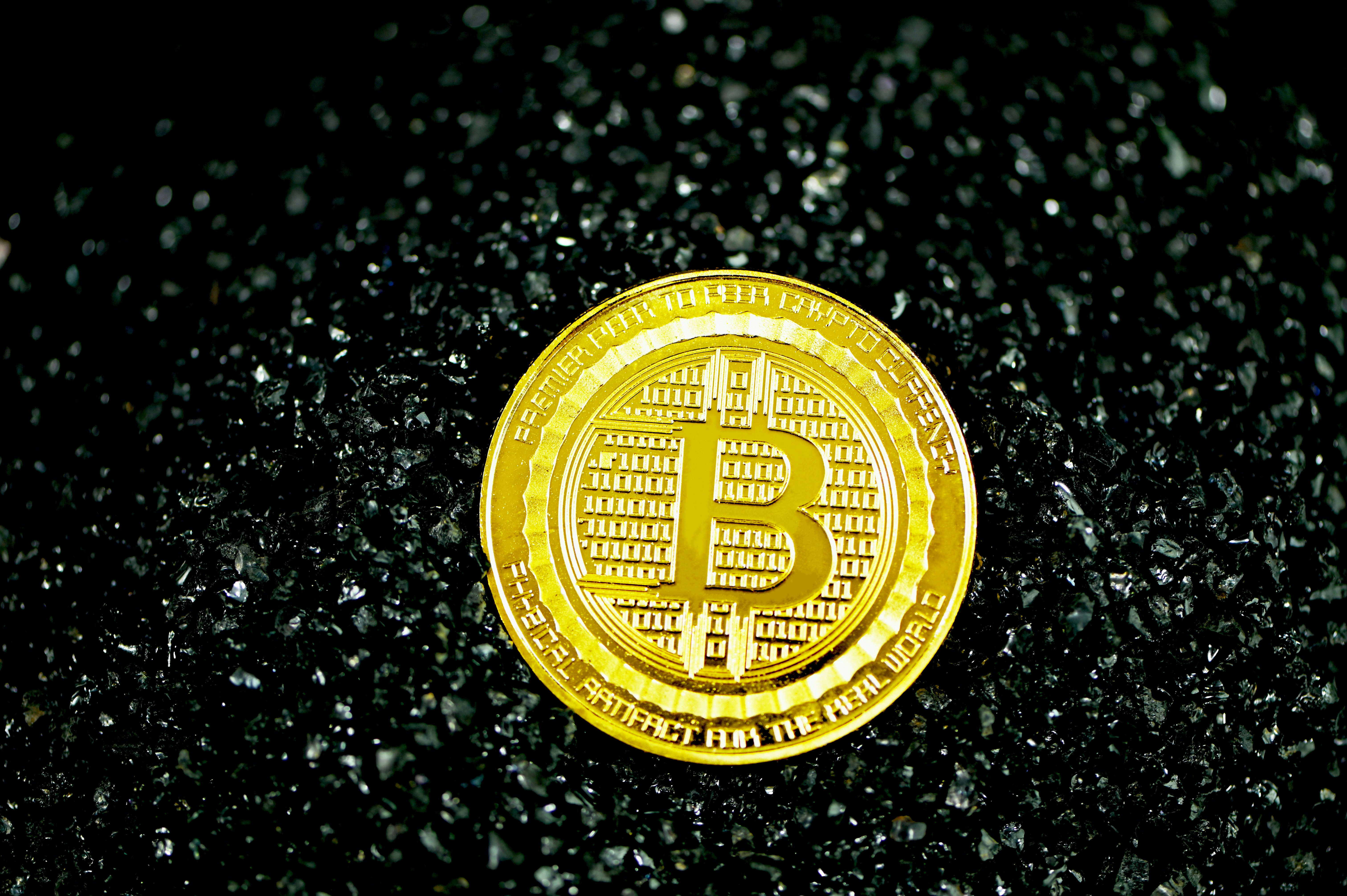 A bitcoin coin on black stones