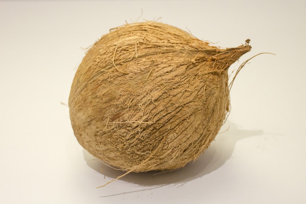 brown round fruit on white surface