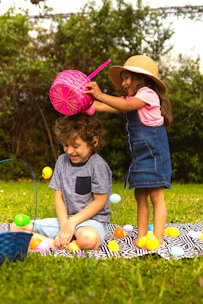 girl in blue dress holding pink plastic bucket