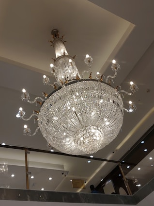 A beautifully lit custom chandelier hanging in a modern living room.