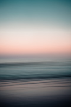 An impressionistic landscape with teal and periwinkle hues blending in rhythmic waves.