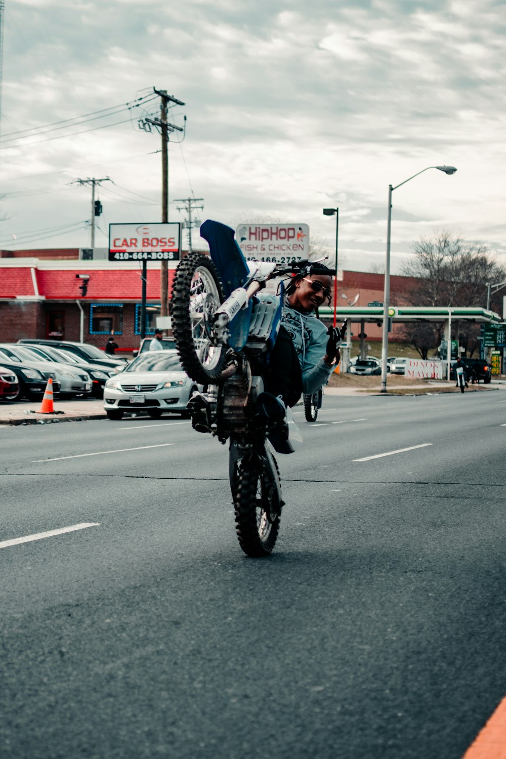 昼間に道路で自転車に乗る黒いジャケットの男性