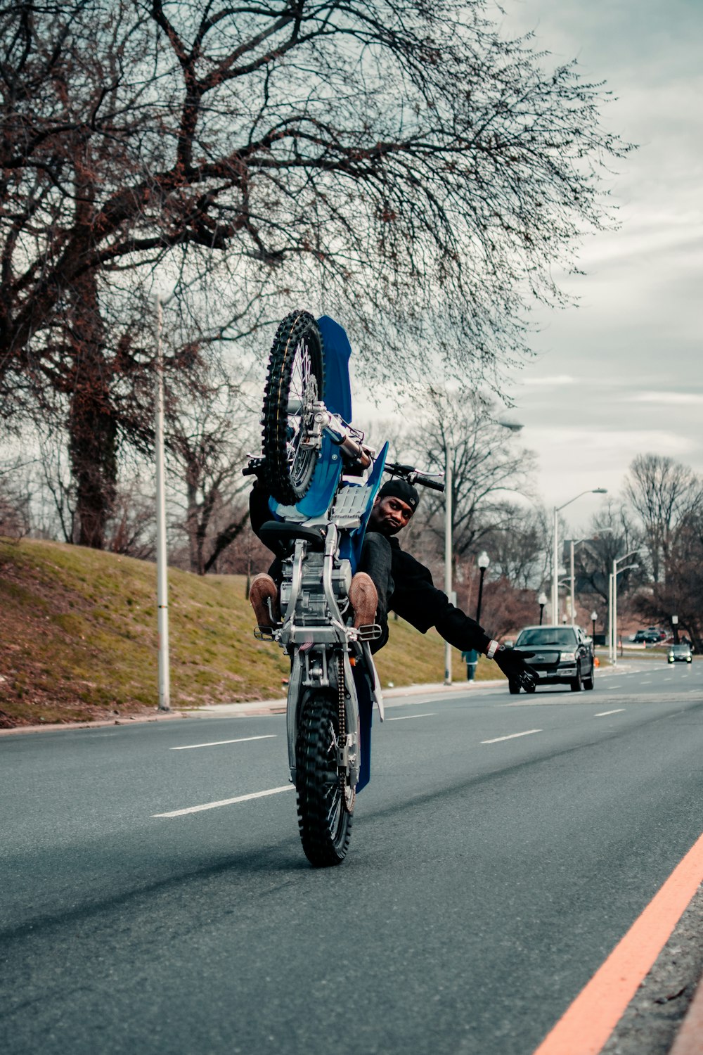 man in black jacket riding bicycle on road during daytime