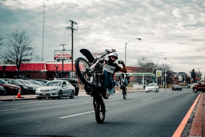 man in red and black motorcycle suit riding motorcycle on road during daytime