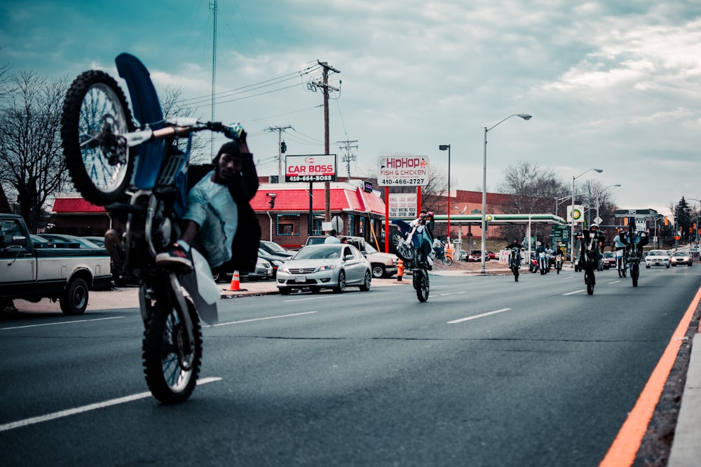 Mann in schwarzer Jacke fährt tagsüber auf dem Motorrad auf der Straße