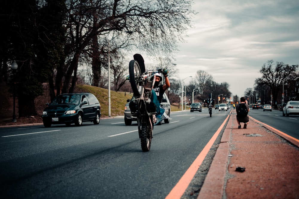 man in red jacket riding motorcycle on road during daytime