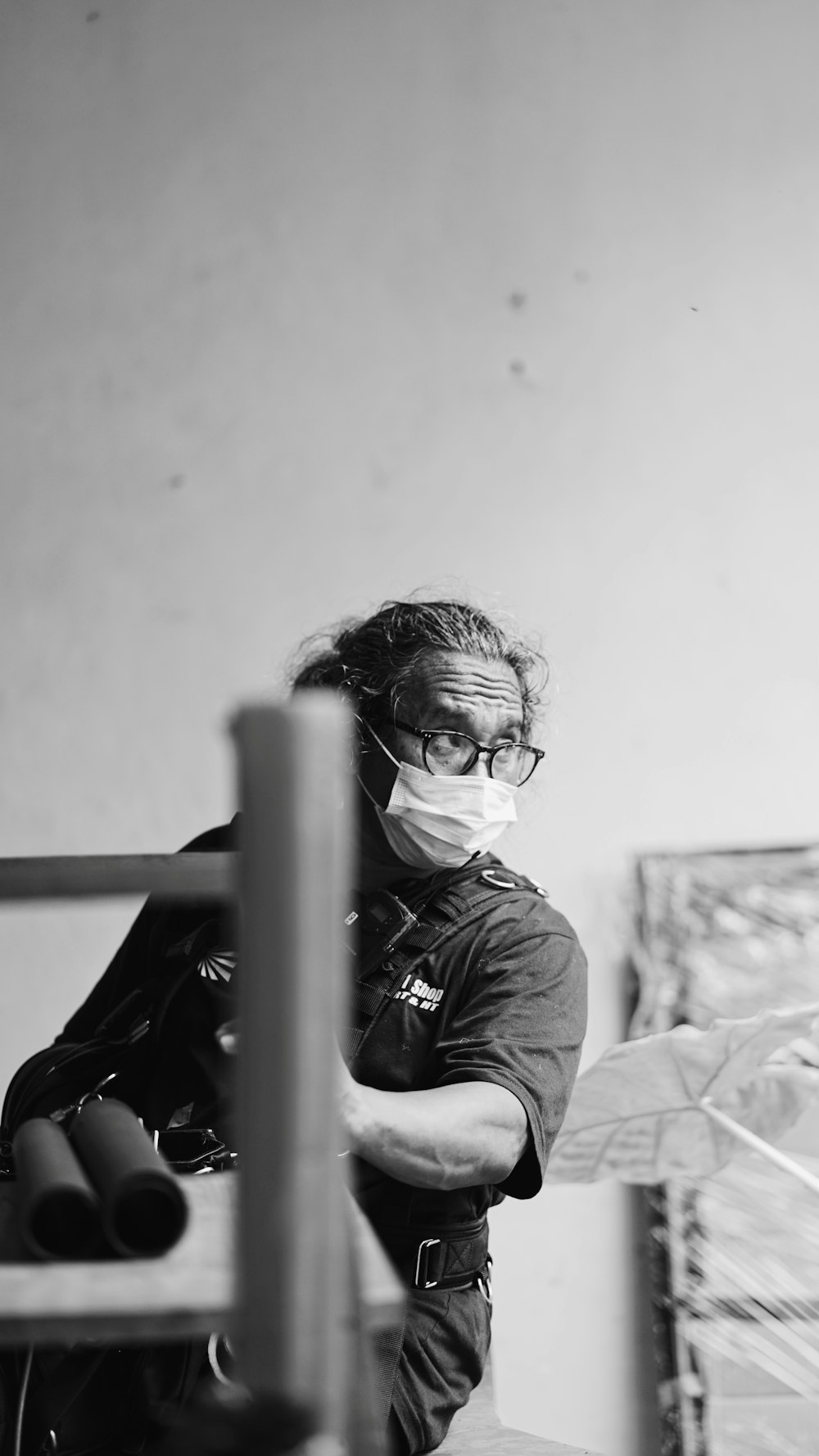 woman in black long sleeve shirt and black framed eyeglasses sitting on bed