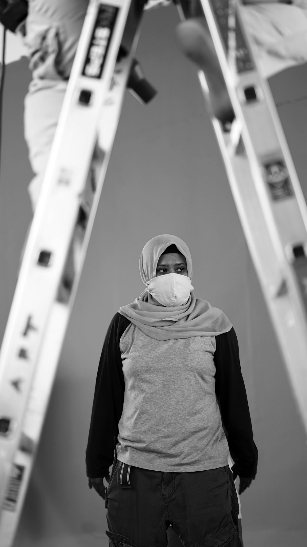 person in gray hijab standing in front of white wall