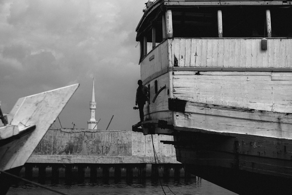 grayscale photo of a white and black wooden house on a dock