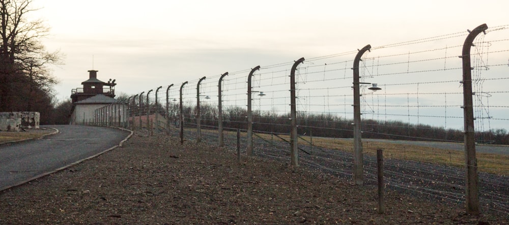 gray metal fence on brown field during daytime