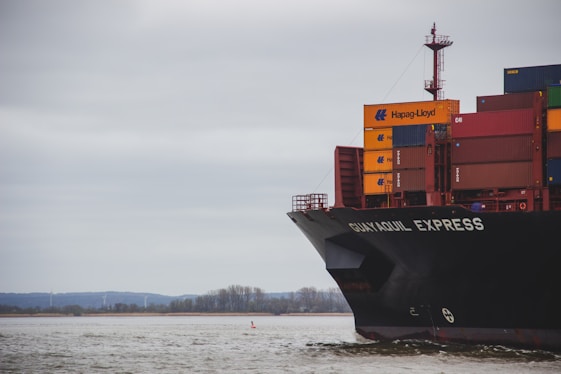 black and red cargo ship on sea under white clouds during daytime