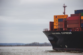 black and red cargo ship on sea under white clouds during daytime