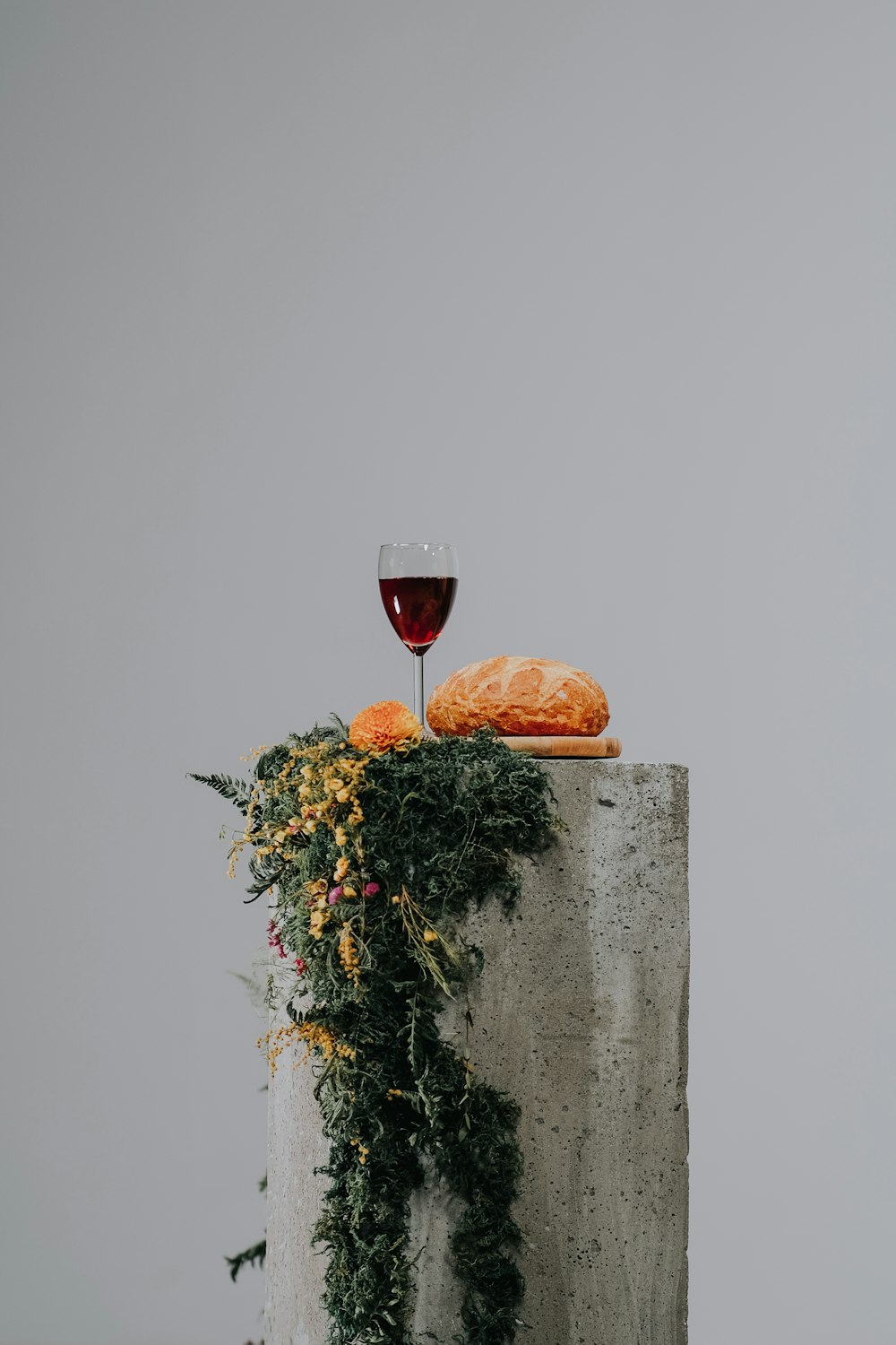 회색 콘크리트 벽에 맑은 와인 잔에 담긴 레드 와인