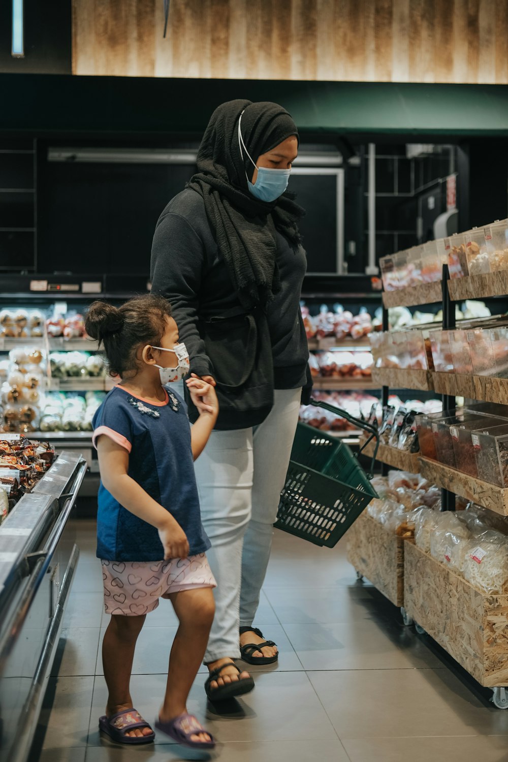 Homme en veste en cuir noir et jeans en jean bleu debout devant le comptoir de présentation des aliments