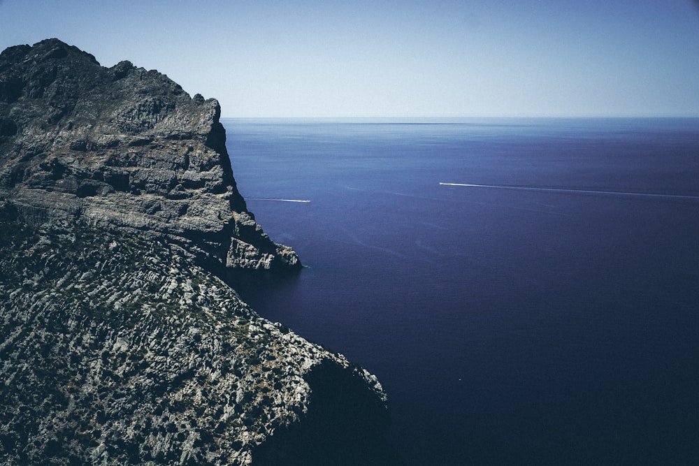 body of water near mountain during daytime