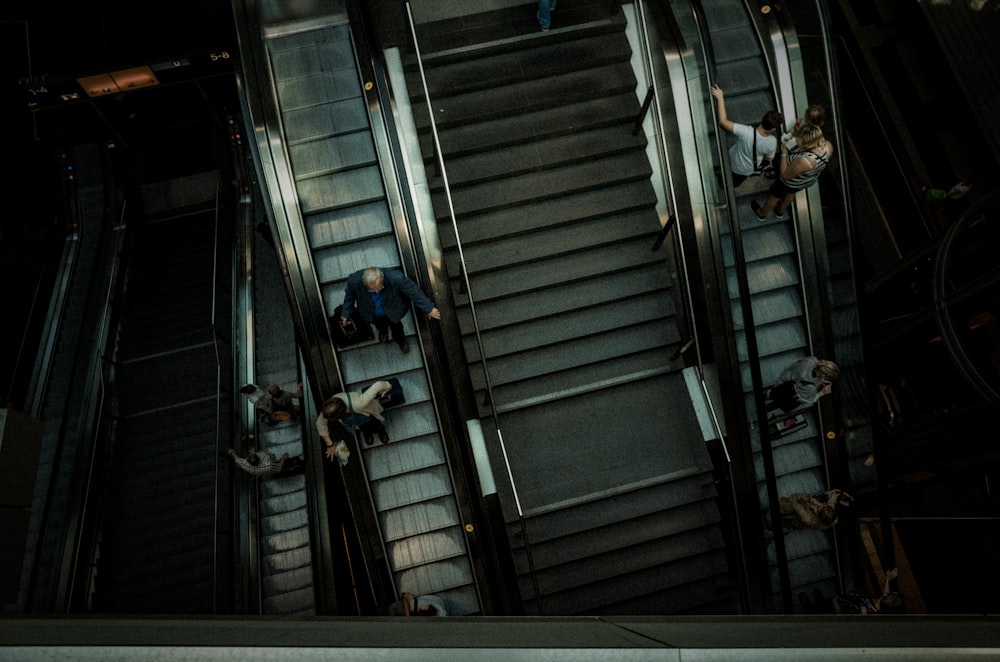 people walking on escalator inside building