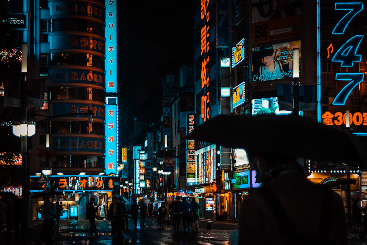 People walking along a wet city street at night