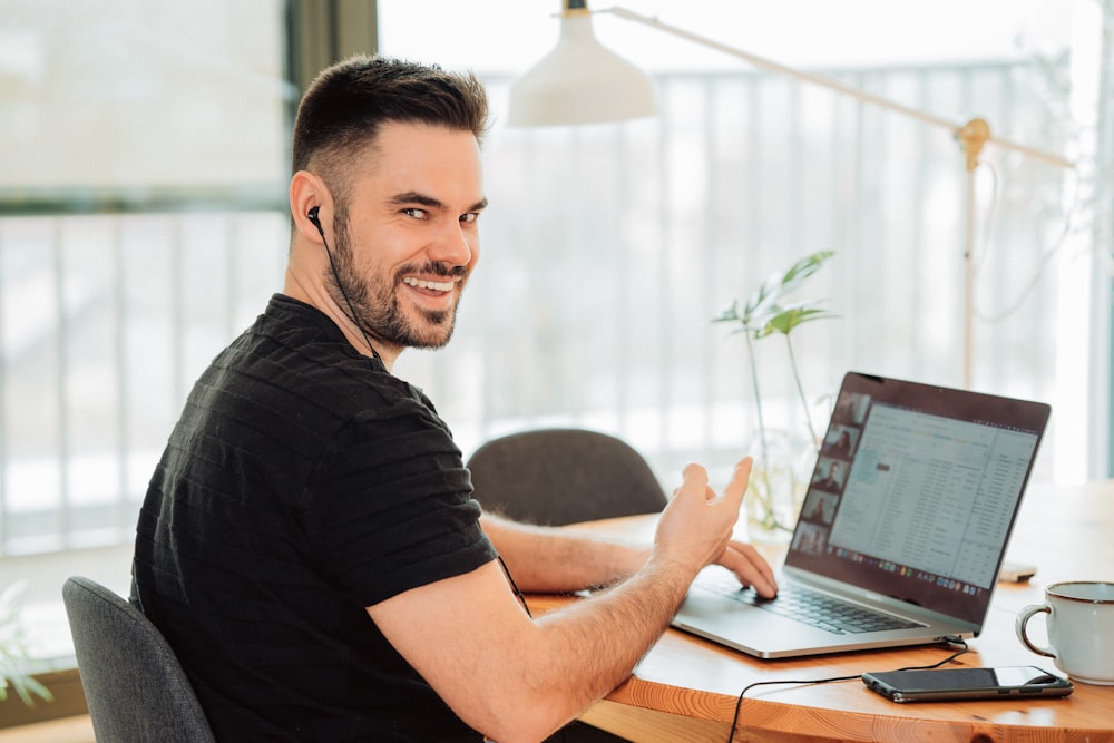 man in black t-shirt using macbook pro